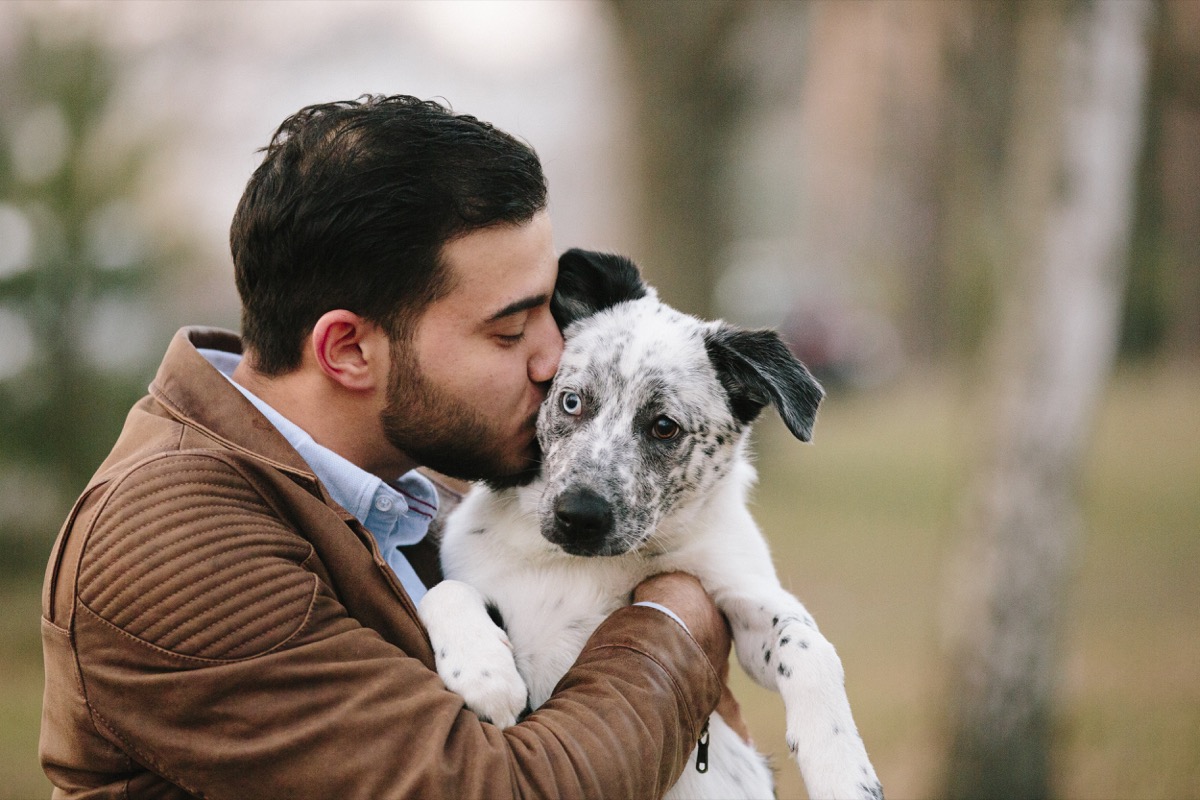 young man, mixed-breed dog, puppy, park