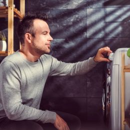 man looking at washing machine setting the presets