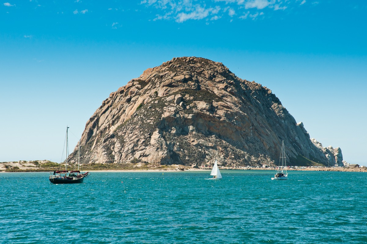 morro bay california with a huge rock formation and sail boats