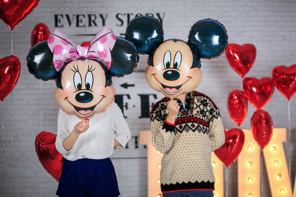 a couple wearing mickey and minnie masks