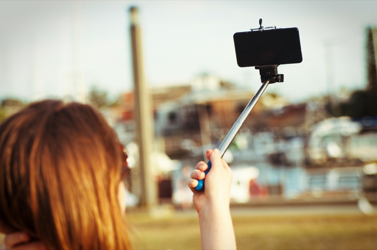 woman taking selfie with self stick