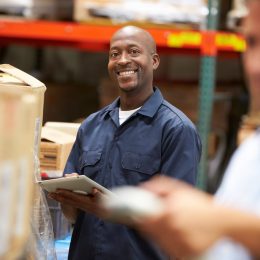 happy warehouse worker smiling while doing inventory