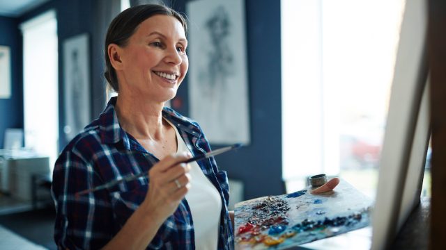 woman in her 50s happily painting