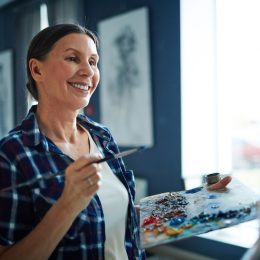 woman in her 50s happily painting