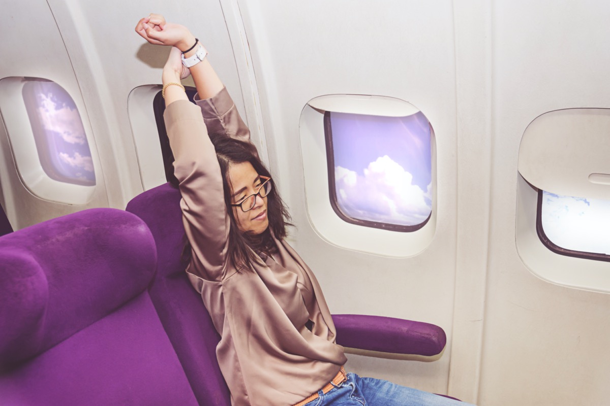 woman stretching during flight