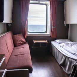 tiny cruise cabin with a single bed and couch
