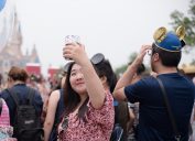 A young chinese woman is taking a selfie at Hong King Disneyland