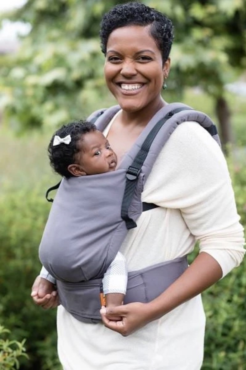 black woman wearing baby daughter in gray Tula carrier