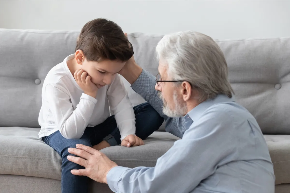 white grandfather and grandson upset on couch