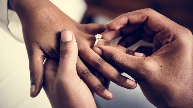 Man putting a wedding ring on his new wife