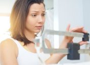 Woman schecking the scale with a concerned look on her face