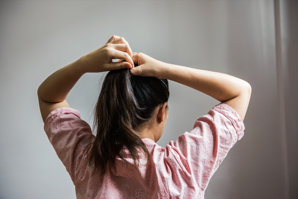 Woman putting her hair in a ponytail