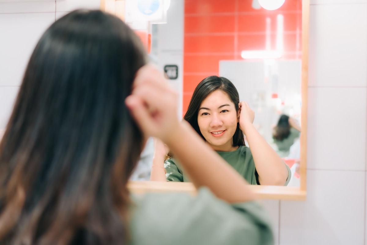 Asian women are looking herself reflection in mirror