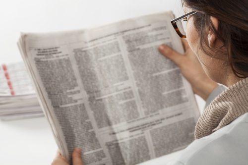 femeie care citește un ziar