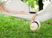 woman relaxing outdoors in hammock with laptop