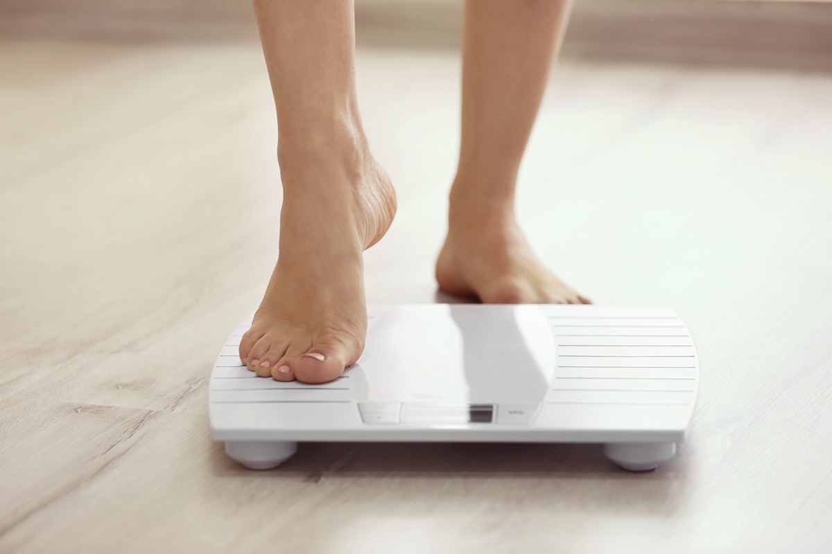 Woman stepping onto a scale to weigh herself