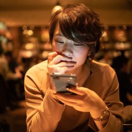young woman using smart phone in cafe after work