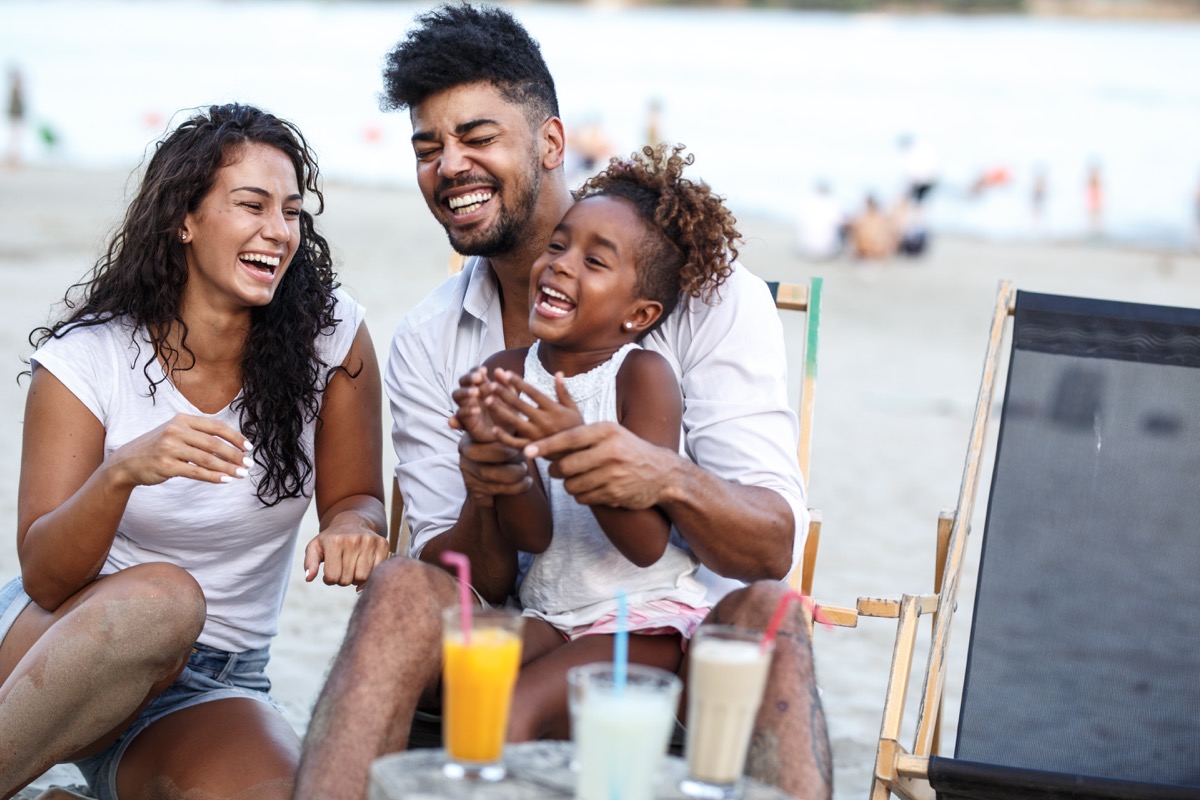 Young family laughing on beach