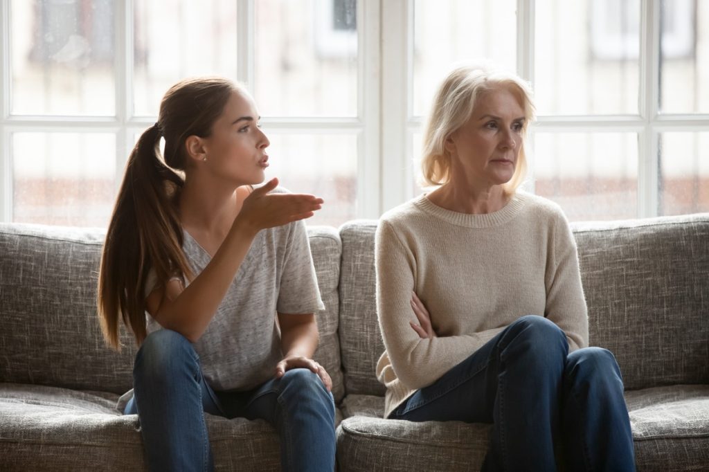 young woman criticizing older woman on couch