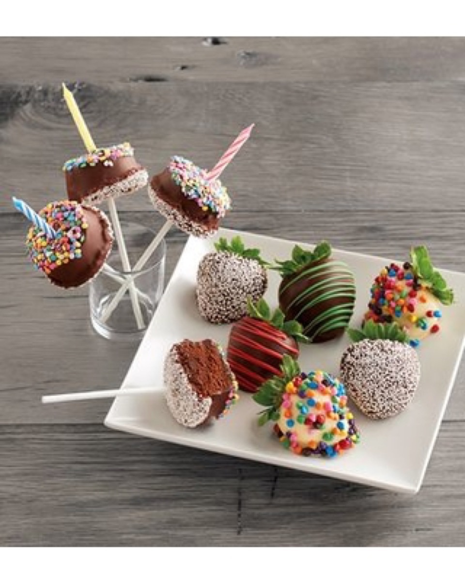 cake pops and chocolate covered strawberries on white plate