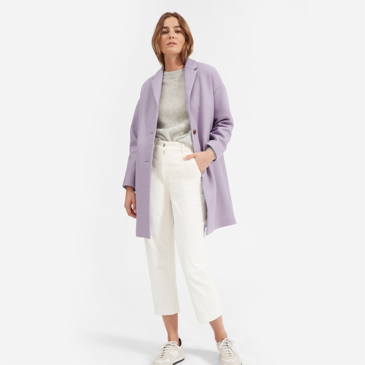 white woman in white pants and purple sweater