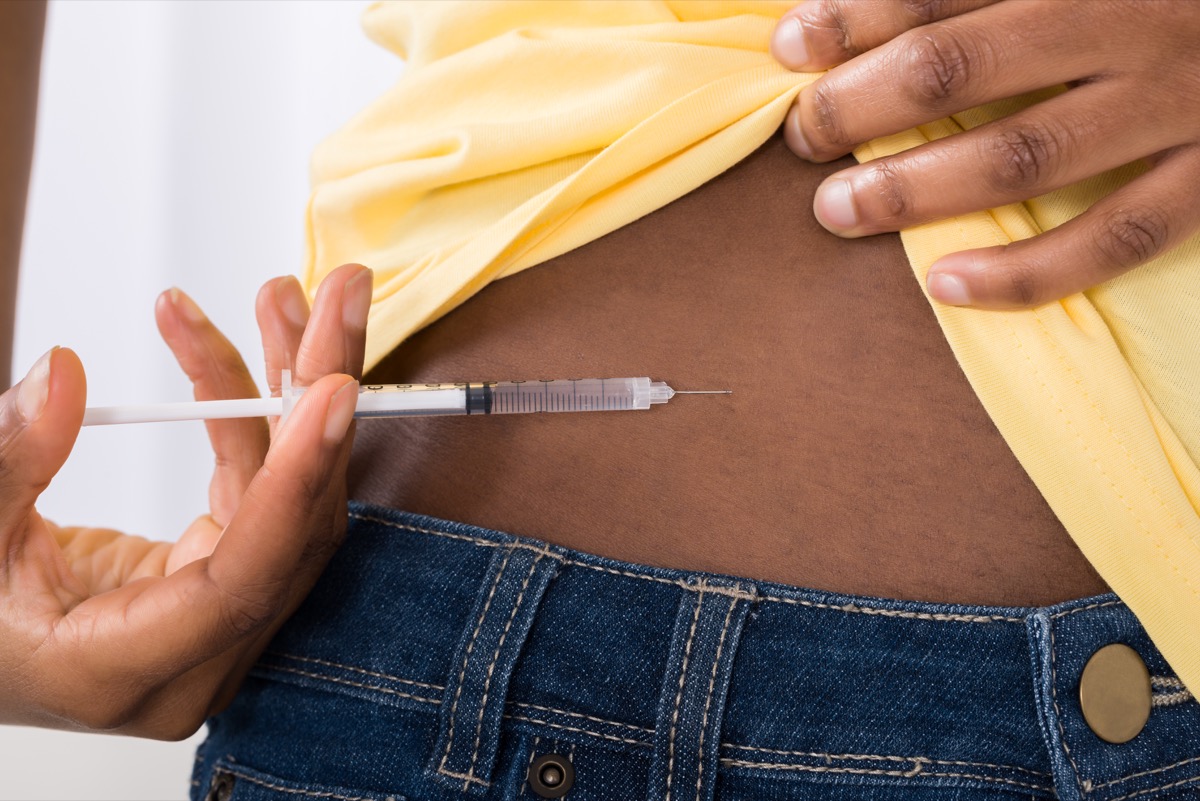 O femeie de culoare injectează insulină în stomac