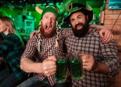 Two men drinking beer in the bar and celebrating St. Patrick's Day