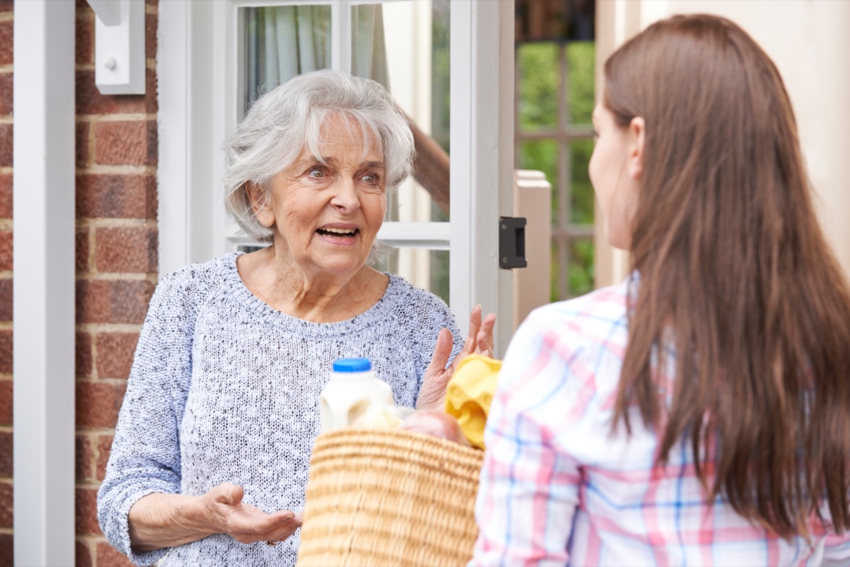 Woman delivering groceries to her elderly neighbor