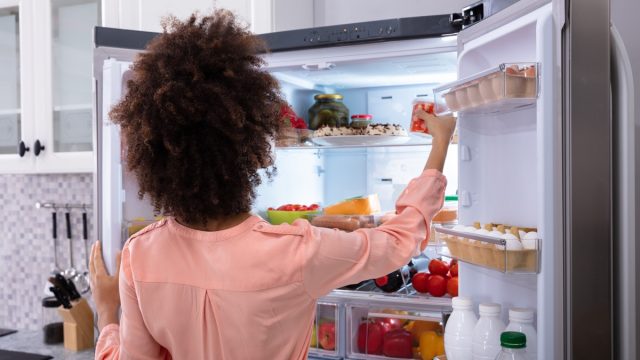 Woman going through refrigerator