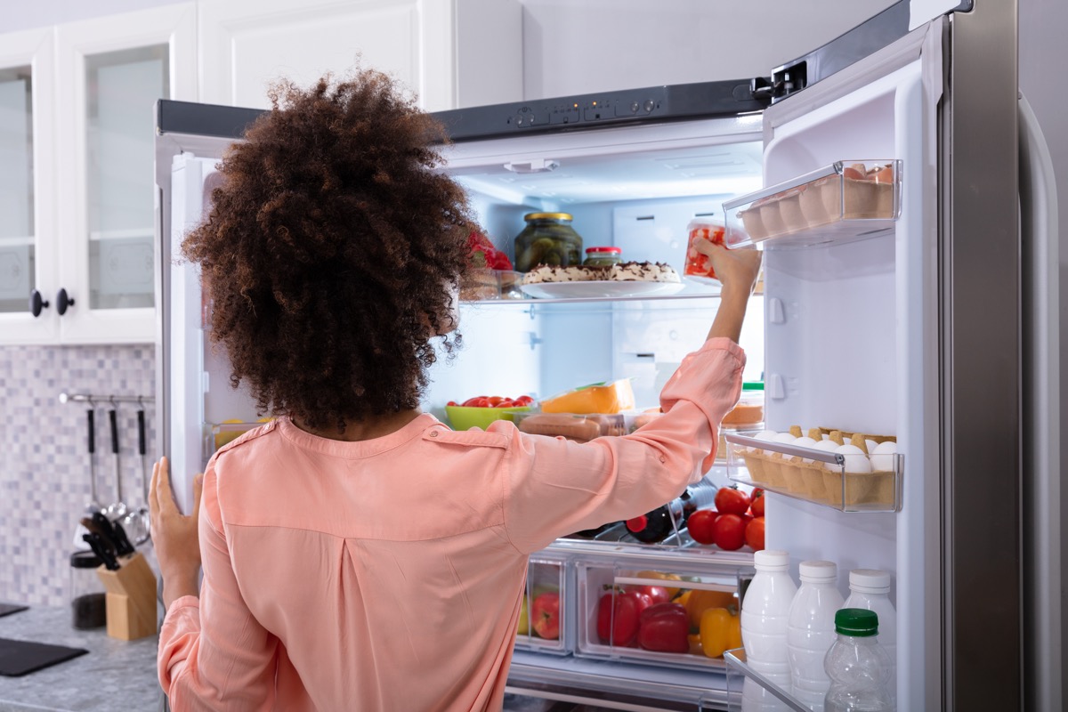 Woman going through refrigerator