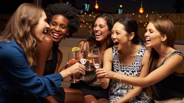 Friends laughing and drinking at a bar