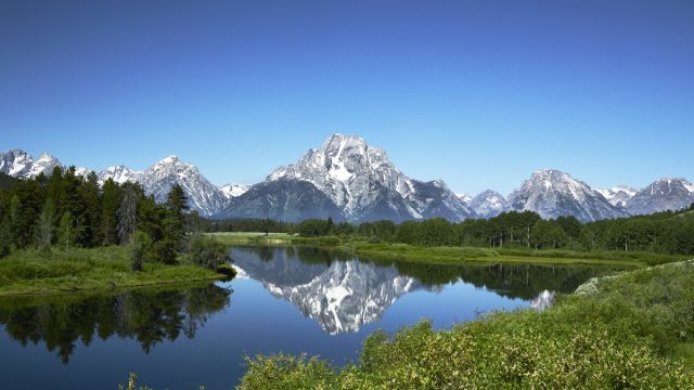 Grand Tetons reflected in still water of the Snake River at Oxbow Bend