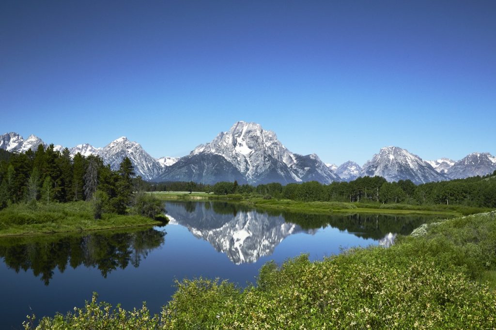Grand Tetons reflected in still water of the Snake River at Oxbow Bend