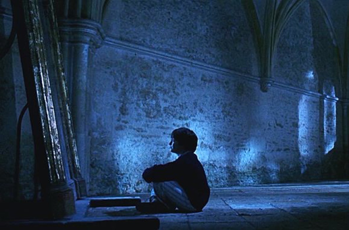 Harry Potter sitting in front of the mirror of erised