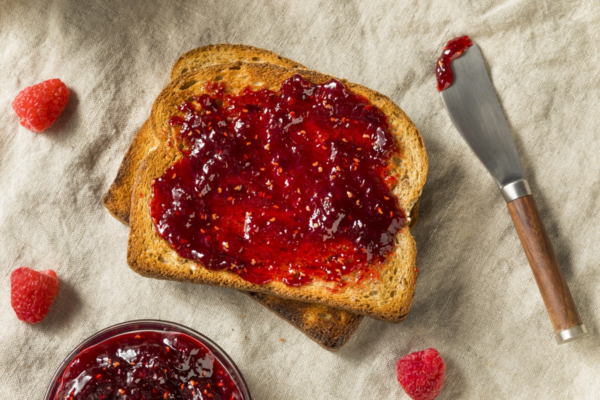 homemade raspberry jam spread on a piece of toast