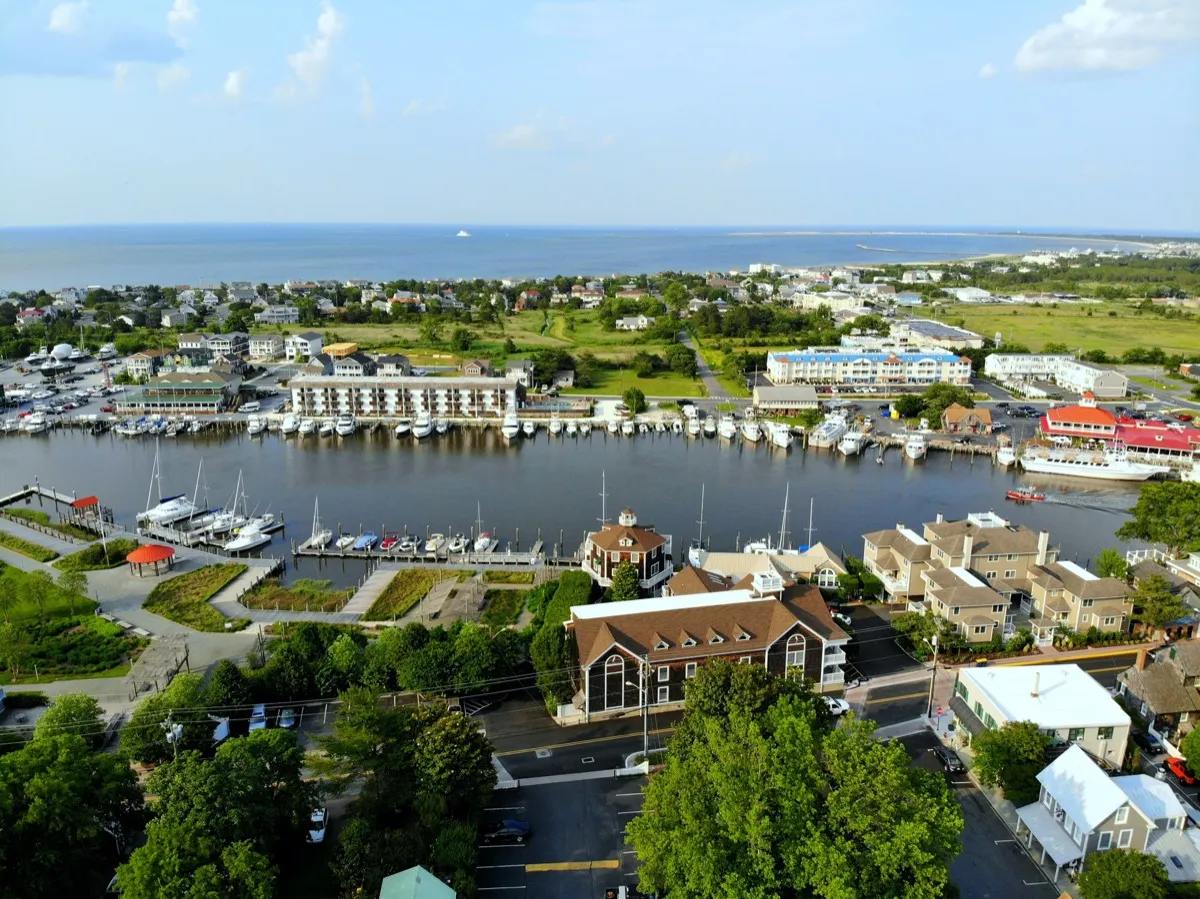 Luftaufnahme der Strandstadt, des Fischerhafens und der Reihenhäuser am Meer entlang des Louis Delaware Canal