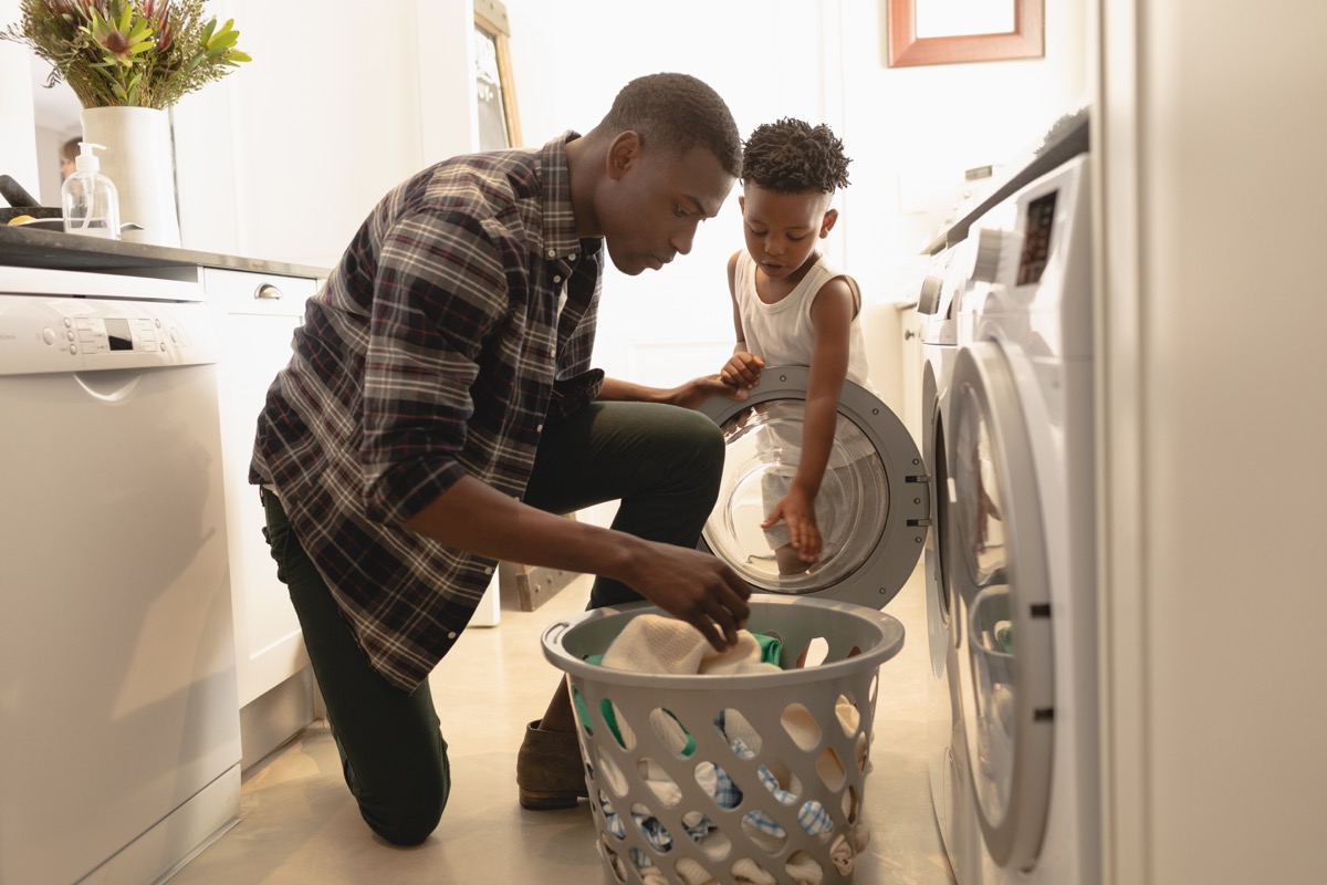 black man and son taking laundry out of dryer