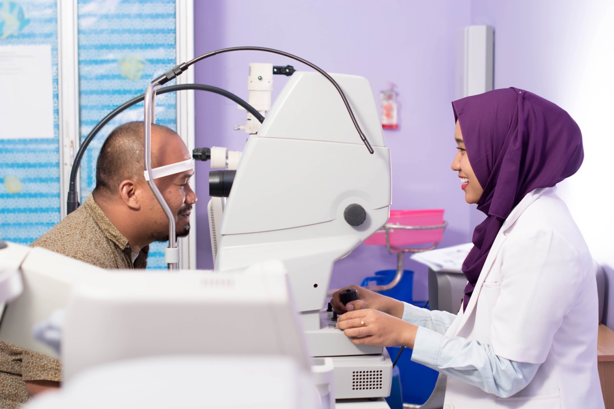 middle aged asian man with female eye doctor wearing hijab