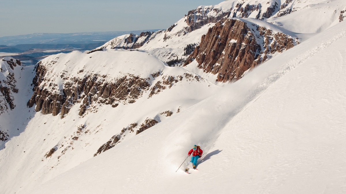man skiing down untouched snow in Utah