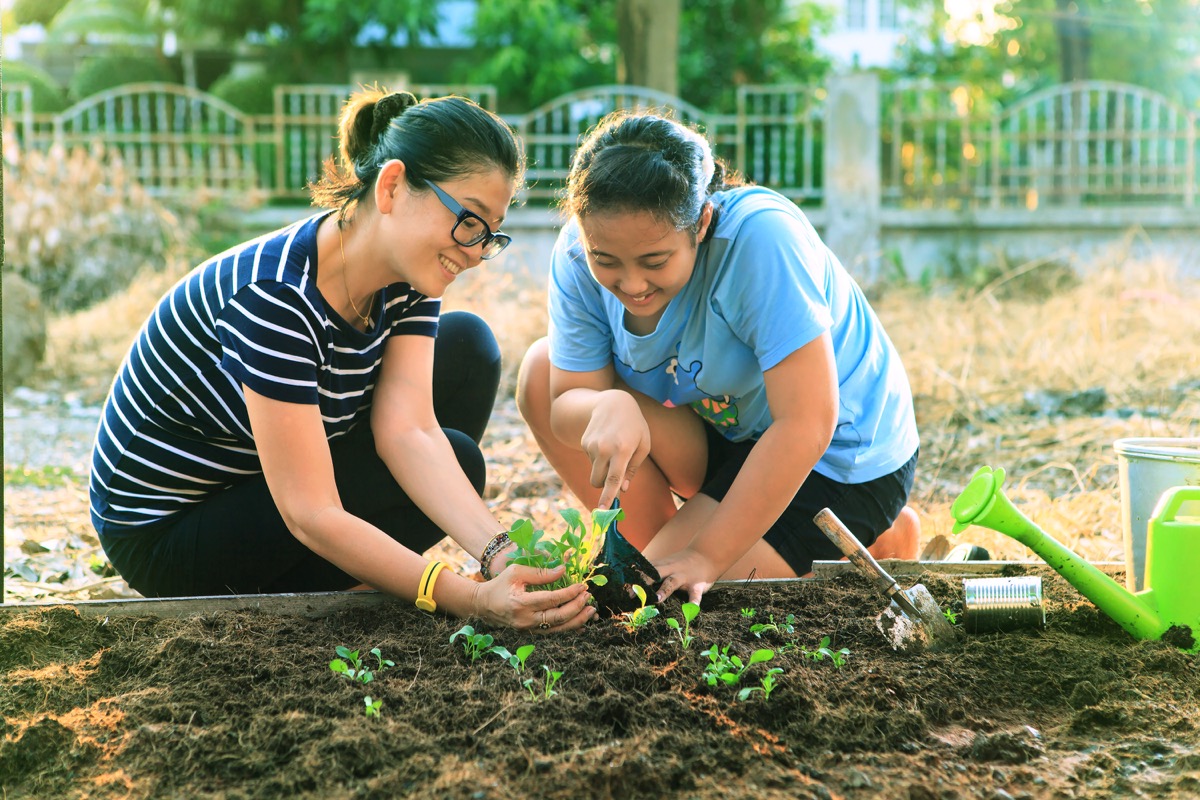 Mother and daughter planting a garden