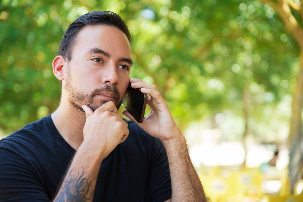 serious man talking on the phone while thinking through his thoughts