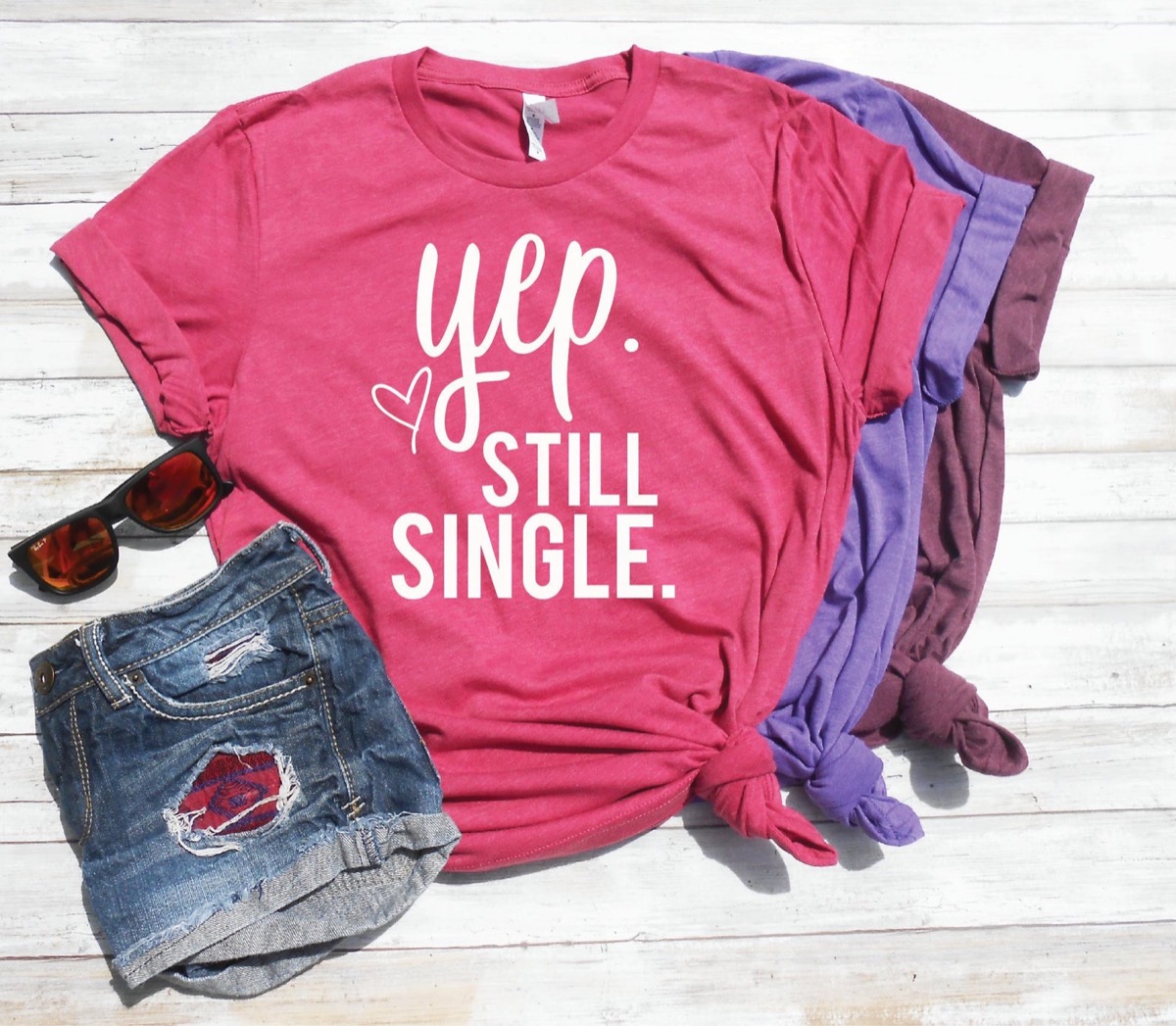 pink shirt with "yep still single" on it