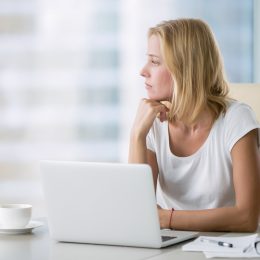 woman looking out window worrying about getting fired