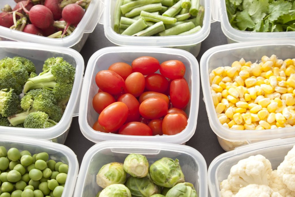 different types of veggies each in a plastic container of tupperware