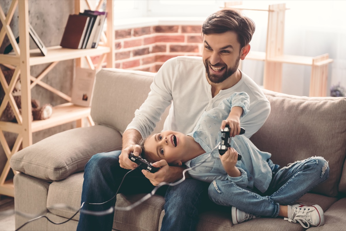 Dad playing video games with his daughter