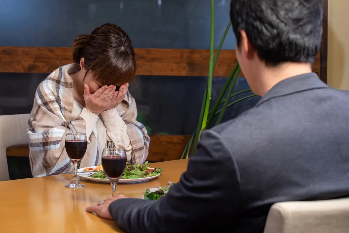 young asian woman crying at dinner
