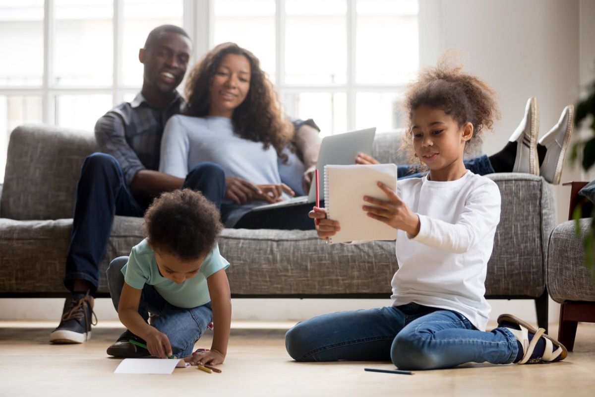 young kids playing together while parents look on