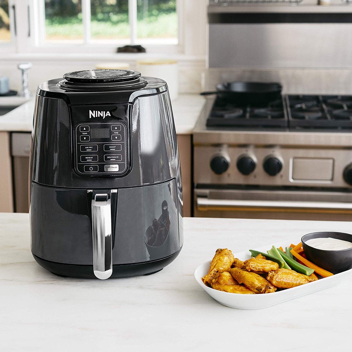 Ninja air fryer on kitchen counter with snacks