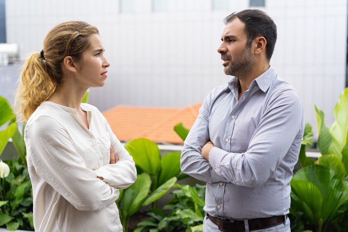 angry man and woman with crossed arms talking