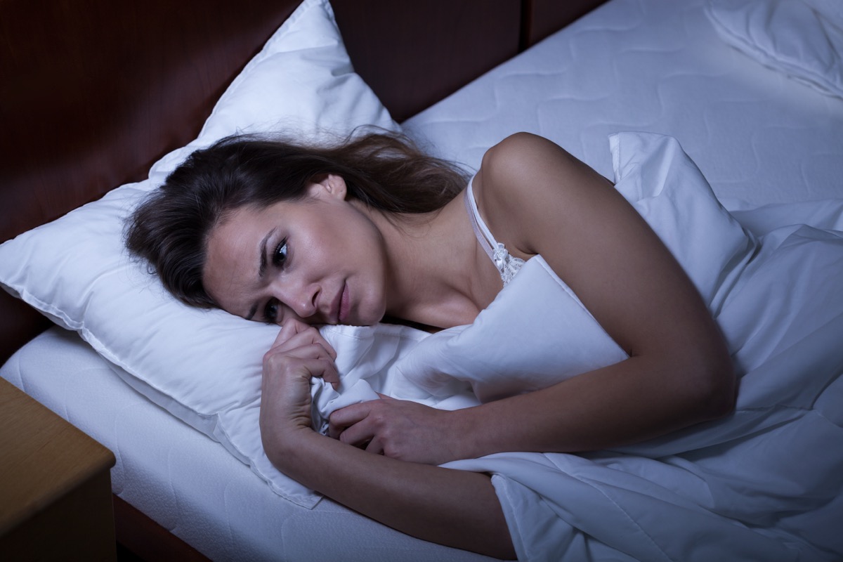 Woman awake in bed can't fall asleep